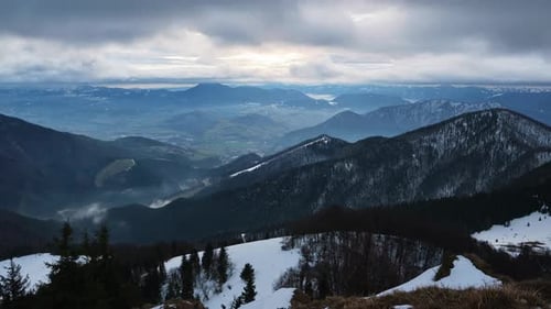 Bergige Hügellandschaft im Winter, bewölktes, windiges Wetter, schnelle Bewegung der Wolken, Zeitraffer