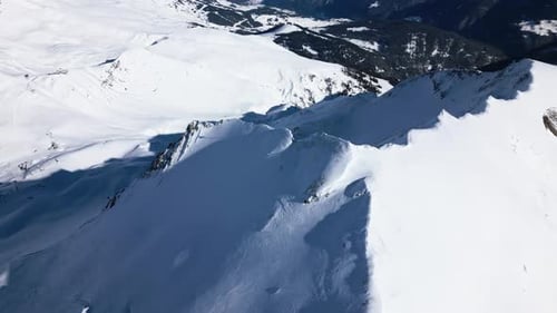 beautiful view over a snow-covered mountain in a ski area. the drone flies around the mountain and r