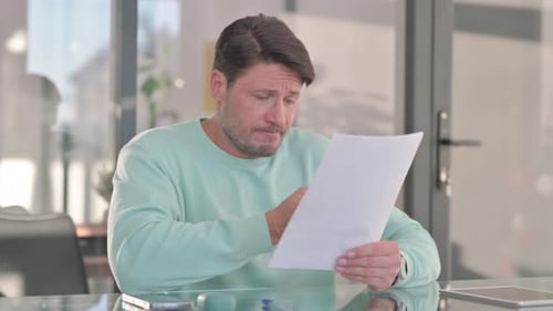 Man Reading Document Appears Worried