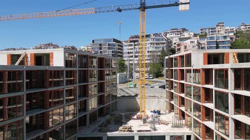 Edificios residenciales modernos en construcción con andamios y grúas capturados en un claro