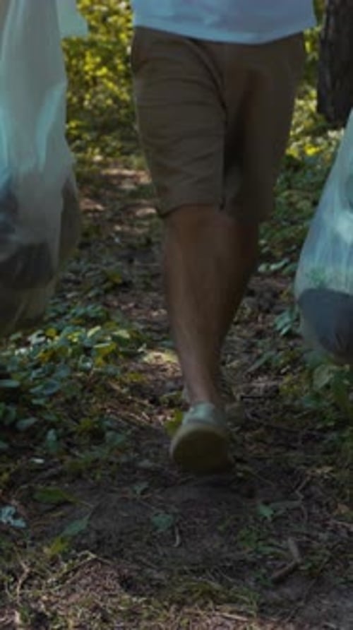Una persona camina por un sendero pintoresco mientras lleva bolsas en medio de la hermosa naturaleza