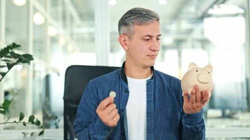 Happy Businessman Saving Money in Piggy Bank for Future Investment