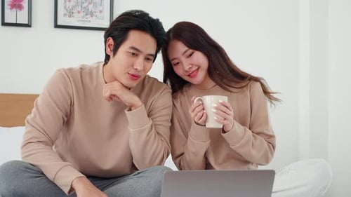 Young Couple Relaxing at Home with Laptop