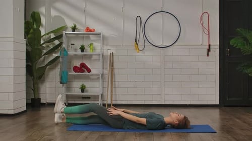 Woman Stretching Legs While Lying on Fitness Mat