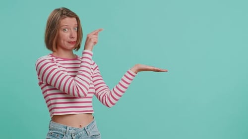 Young Woman Showing Thumbs Up and Pointing at Left on Blank Space Place for your Advertisement Logo
