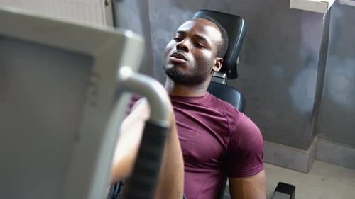 Black Man Weightlifter Doing Leg Presses in Gym