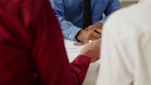 Nahaufnahme von Geschäftspartnern, die an Papierkram arbeiten und Brainstorming machen.