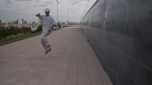 Man Roller Skater in Helmet Shows Various Jumps on Paved Track