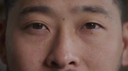 Extreme Close Up of an Asian Man Eyes Open and Looking at Camera in Slow Motion