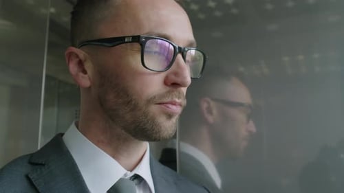 Man in Suit with Glasses Rides Elevator
