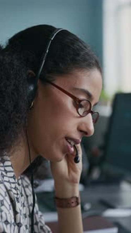 Operator of Call Center Talking to Online Client in Headset Microphone