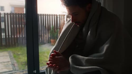 Depressed man covered with a blanket
