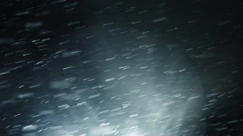 Snow Falling in the Dark City at Night