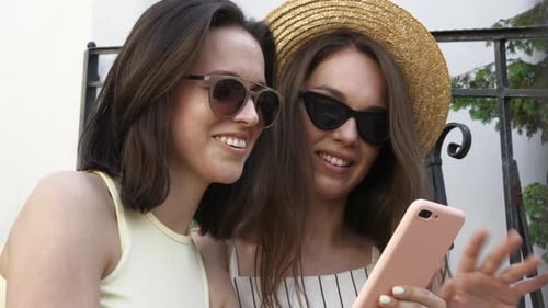 Young Women Looking at a Smartphone and Laughing