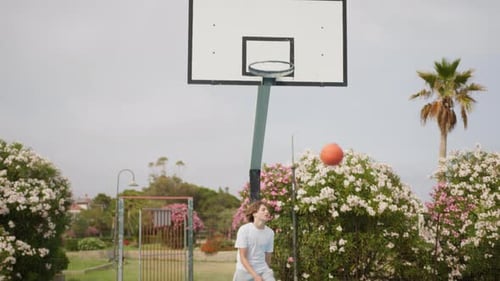 Two Caucasian Little Boys Playing Hopscotch Basketball On Blue Court Outdoors
