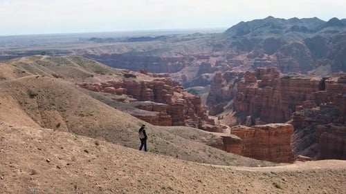 Ein junger Reisender geht am Rand der Klippe spazieren und genießt die Landschaft Hochwertiges Filmmaterial