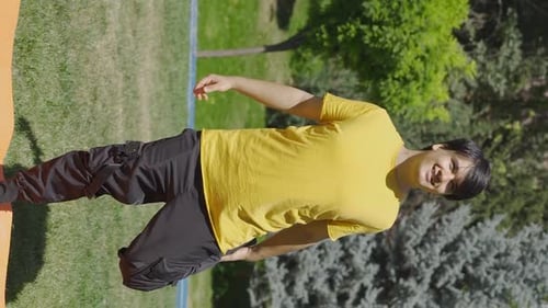 Young Adult Stretching in a Sunny Park