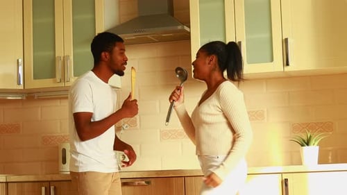 Young Couple Dancing and Singing in Kitchen