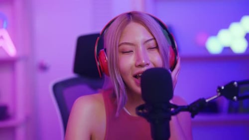 Asian young audio DJ woman sing a song on microphone to broadcasting.