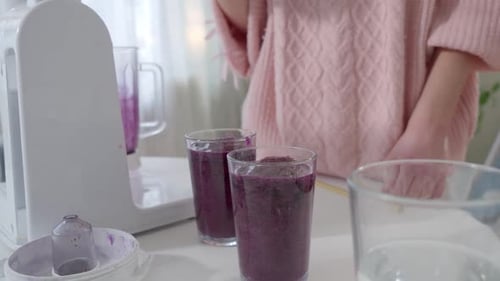 Girl Drinks Purple Smoothie in Kitchen