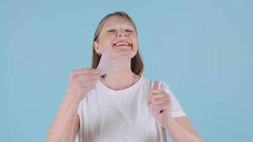 Woman Demonstrates Facial Massage with Gua Sha Tool