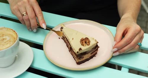 Woman Enjoys Slice of Raw Glutenfree Cake at Cafe Table with Cappuccino