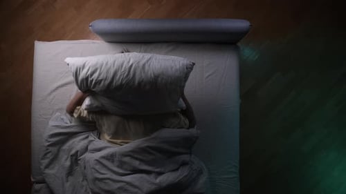 Man Tossing and Turning in Bed at Night