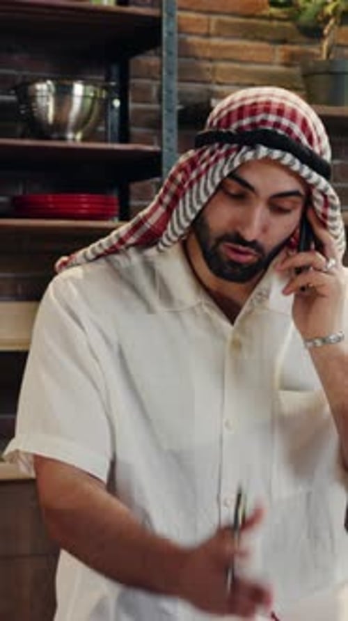 Bearded Adult Talking on Smartphone and Taking Notes