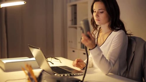 Woman Working Late on Laptop and Talking Phone