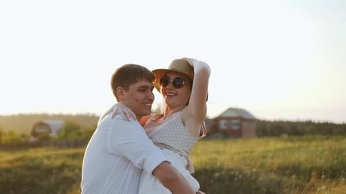 Affectionate Couple Embraces in Golden Field at Sunset