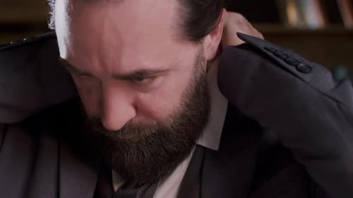 Professional Man with a Beard Meticulously Adjusting His Suit and Tie in Closeup Shots