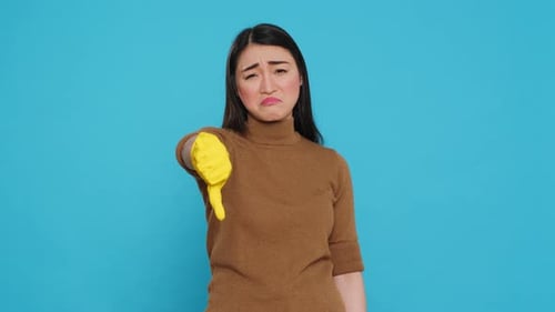 Woman in Glove Gives Thumbs Down Gesture