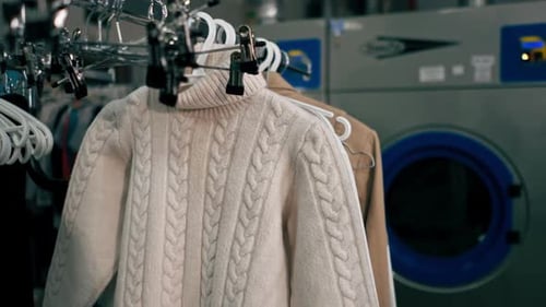 Close Up Professional Dry Cleaning Stand with Different Textile Clothes on Hangers