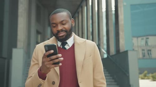 Smiling African American Young Attractive Man Use Phone Walk on Street Sunlight Sunset Cellphone
