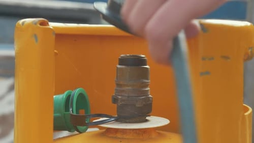 Connecting Regulator to Yellow Gas Cylinder Close Up