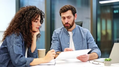 Business Colleagues Collaborate on Documents in Modern Office Meeting