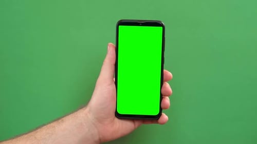 Young Man Hand Use Smartphone with Green Screen on Green Background