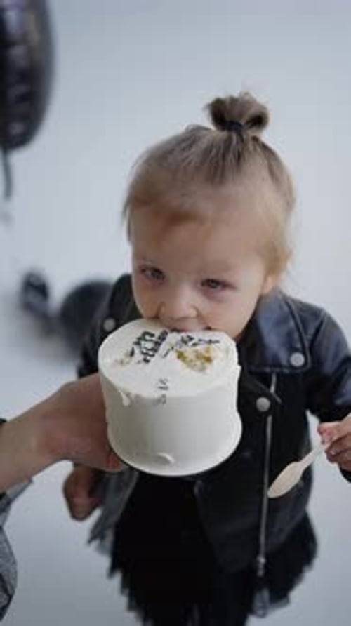 A Child Bites a Piece of Cake