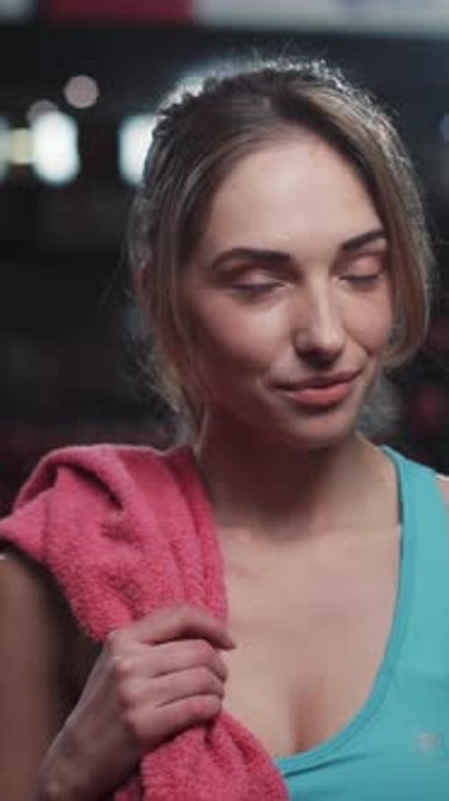 An Active Woman Engaged in a Gym Class Wiping Sweat with a Towel During Her Workout