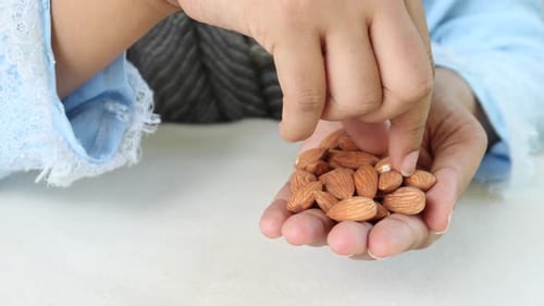 Close Up of Hand Picking Through Almonds