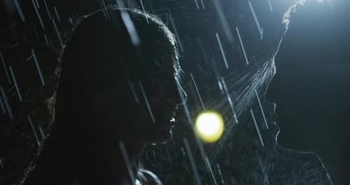 Silhouette of Couple Kissing in the Rain at Night