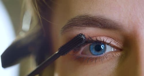 Woman Applies Mascara for Eye Beauty
