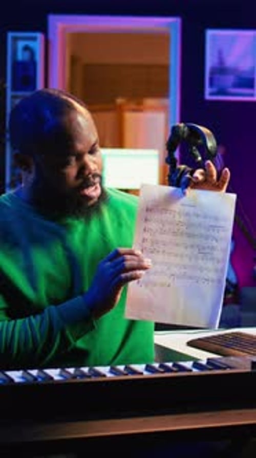 Adult Playing Keyboard and Explaining Music in Studio