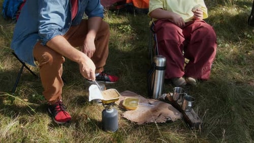 Man and Young Woman with Down Syndrome Cooking Food in Camp in Forest