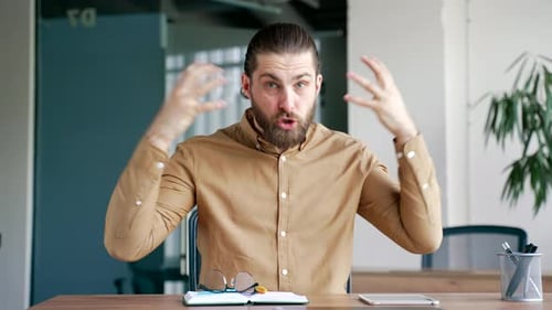 Webcam view. Angry businessman arguing talking on video call looking at camera in office. Excited