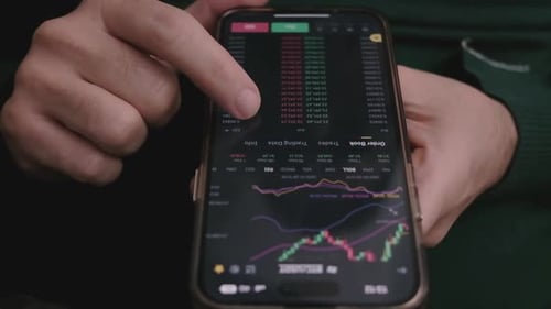 Hand Navigating Trading App on Smartphone