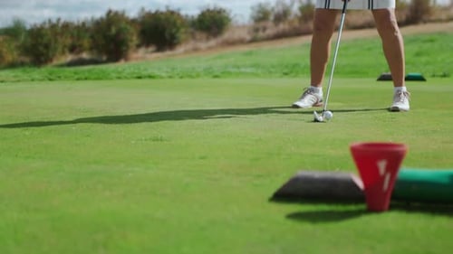 Confident Sportswoman Warming Up and Hitting the Ball with a Golf Club