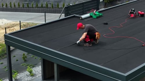 Roofing Project in Progress With Workers Applying New Material on Residential Building