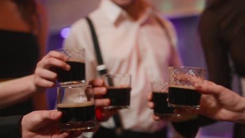 Friends Clinking Glasses in Dark Birthday Celebration