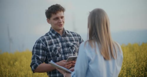 Farmer And Agronomist Discussing In Farm During Sunset